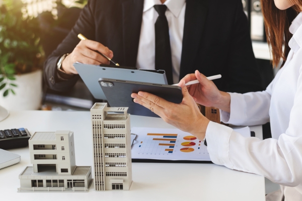 Free Trade Zone Investment Planning and Real Estate Development Meeting Business professionals analyzing investment data with architectural models of commercial buildings for Free Trade Zone development